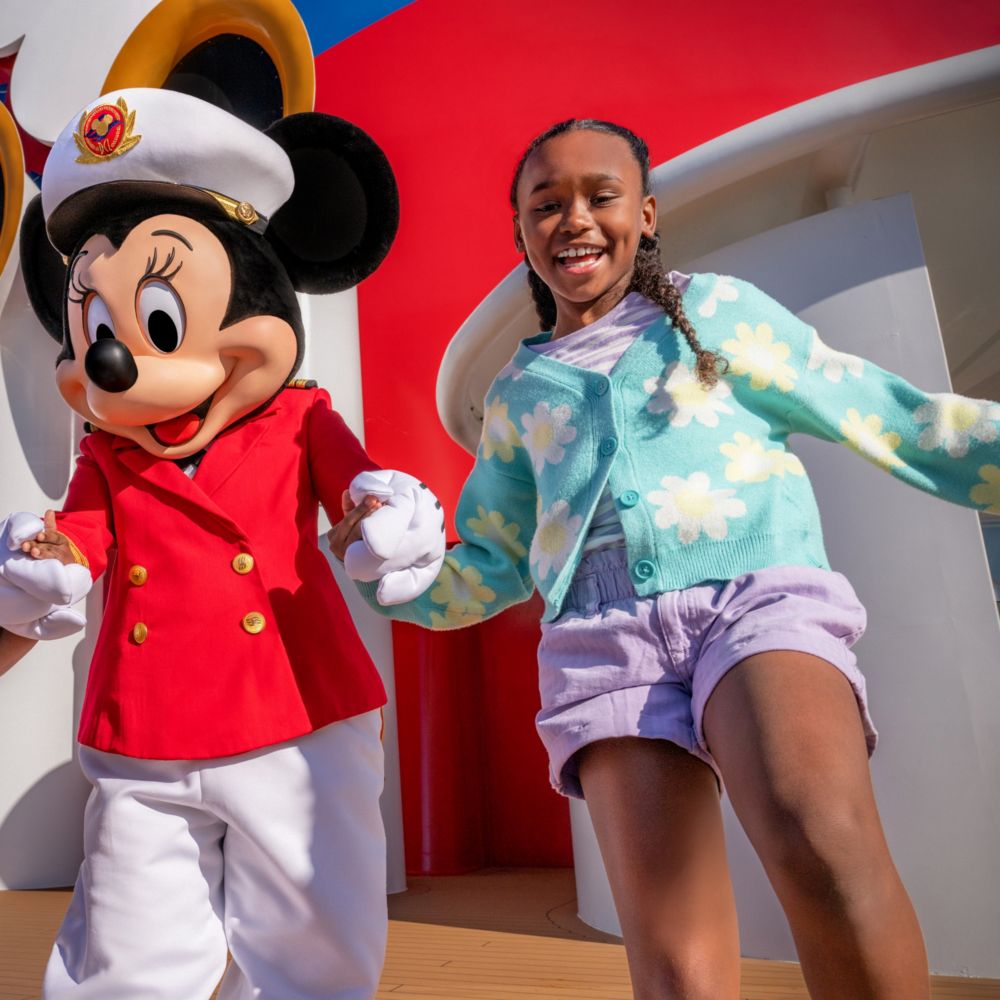 Una niña junto a la capitana Minnie en la cubierta de un crucero